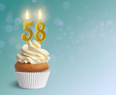 Açık mavi arkaplanda yanan mumlar, yazı için yer olan leziz bir kek. 58. yaş günü veya diğer özel günler