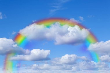 Mavi gökyüzünde parlak gökkuşağı güneşli bir günde bulutlarla