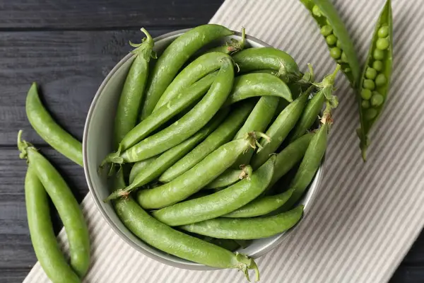 Taze taze bezelyeler siyah ahşap masada, düz yatıyordu.