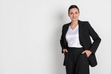Hafif arka planda takım elbiseli kendine güvenen bir iş kadını. Metin için boşluk