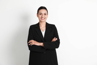 Hafif arka planda takım elbiseli kendine güvenen iş kadını.