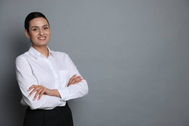 Gri arka planda kendine güvenen bir iş kadınının portresi. Metin için boşluk