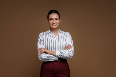 Kahverengi arka planda kendine güvenen bir iş kadını portresi
