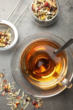 Aromatik bitkisel çay ve kuru yapraklar gri masada, düz yatıyordu.