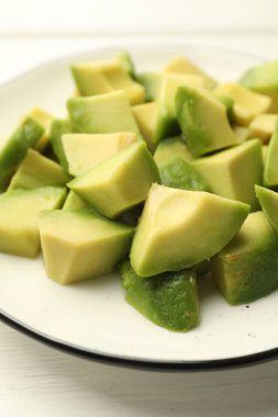 Beyaz ahşap masada lezzetli avokadolar, yakın plan.