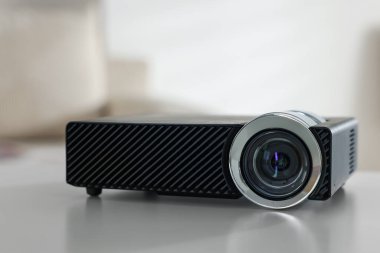 Beyaz masa üzerinde modern video projektörü, yakın plan.