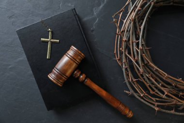 Yargıç tokmağı, dikenli taç, İncil ve haç siyah masada, düz yatıyordu.