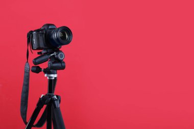 Kırmızı arkaplanda modern profesyonel video kamera, metin için boşluk