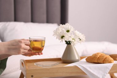 Kadın yatakta nefis bir kahvaltı yapıyor, yakın plan.