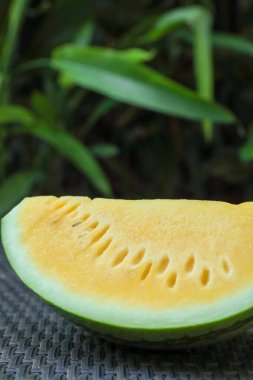 Dışarıdaki hasır masada leziz bir karpuz dilimi, yakın plan.
