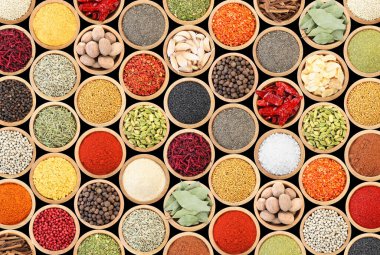 Siyah arka plandaki kaselerde farklı aromatik baharatlar dizisi.