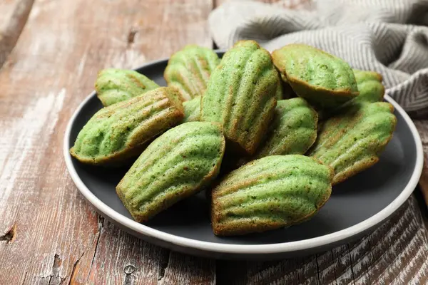 Lezzetli Matcha Madeleine kekleri ahşap masada, yakın plan.
