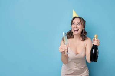 Doğum günü kutlaması. Açık mavi arka planda köpüklü şarabı olan kadın. Metin için boşluk