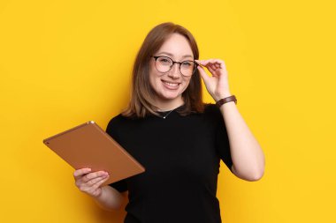 Turuncu arka planda modern tabletli kadın.