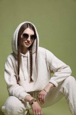 Yeşil arka planda şık giyinmiş güzel bir kadının moda portresi.