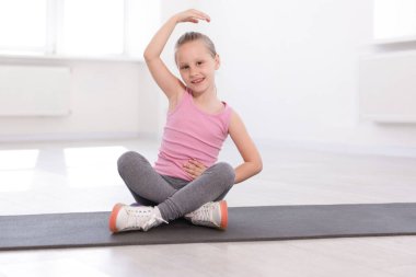Kapalı alanda yoga yapan mutlu kız.