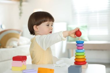 Masada oyuncak piramidiyle oynayan sevimli küçük çocuk.