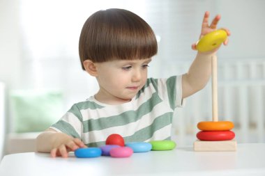 Masada oyuncak piramidiyle oynayan sevimli küçük çocuk.