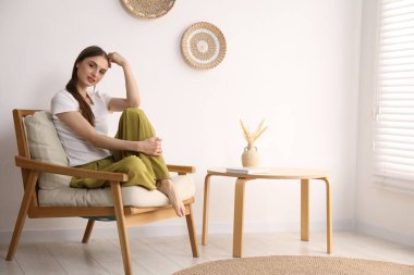 Evdeki rahat koltukta dinlenen güzel kadın.