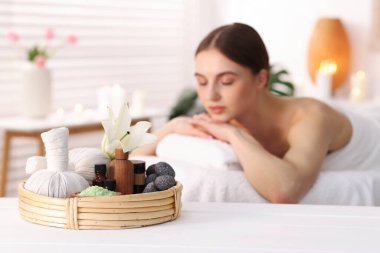 Güzel bir kadın masaj salonundaki masaj koltuğunda dinleniyor, seçici bir odak noktası.