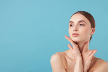 Açık mavi arka planda büyüleyici genç bir kadının portresi. Metin için boşluk