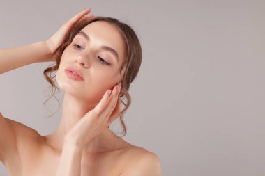 Açık gri arka planda çekici genç bir kadının portresi. Metin için boşluk