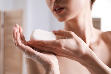 Kadın ellerini içeride sabunla yıkıyor, yakın plan.