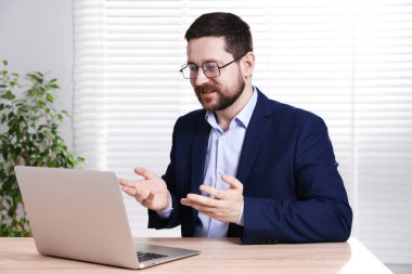 Gülümseyen çevrimiçi hoparlör masadaki dizüstü bilgisayarla internetten yayın yapıyor.