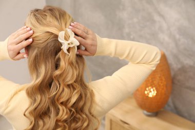 Saçları güzel kıvırcık, arka manzaralı bir kadın.