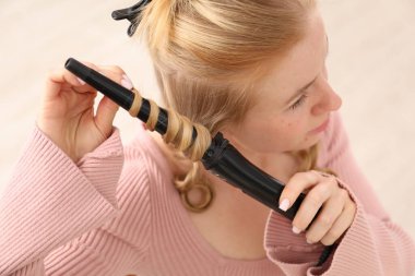 Güzel saçlarını içeride kıvıran kadın, yakın plan.