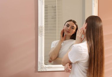 Güzel kadın aynada kendine bakıyor, mesaj için yer var.