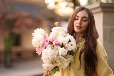 Şehir caddesinde elinde şakayık demeti olan bir kadın. Metin için boşluk