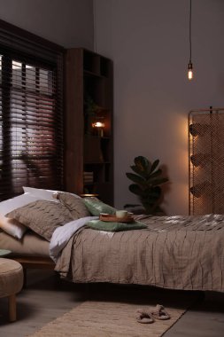 Yatak odasında güzel çarşafları olan rahat bir yatak.