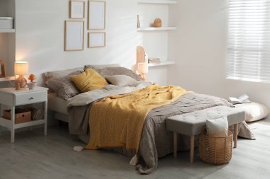 Yatak odasında güzel çarşafları olan rahat bir yatak.