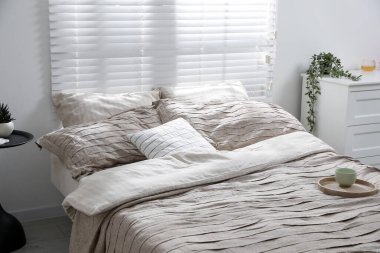 Yatak odasında güzel çarşafları olan rahat bir yatak.