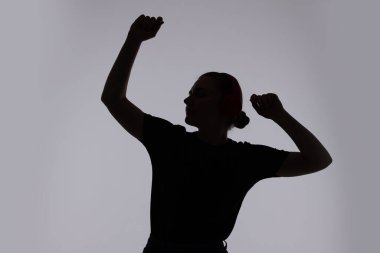 Gri arka planda poz veren kadın silueti