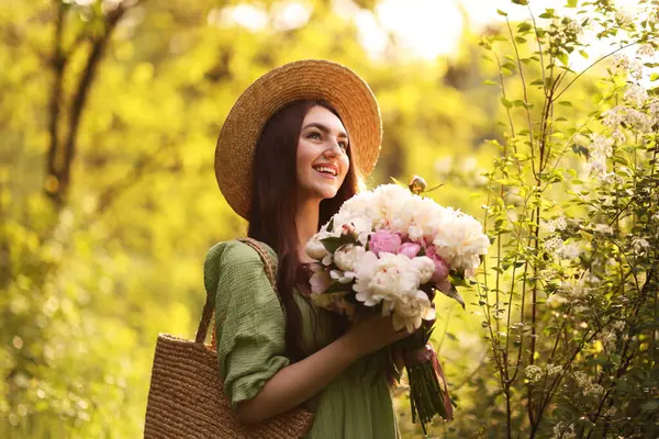 Parkta şakayık demeti olan güzel bir kadın.
