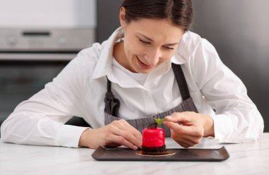 Şekerci, masada nane şekeriyle lezzetli bir tatlı hazırlıyor.