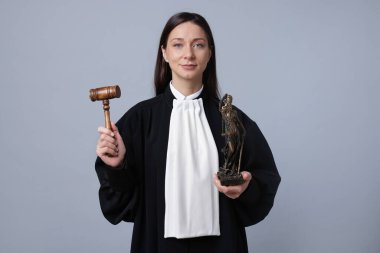 Bayan Adalet 'in gri arka planında tokmakla ve figürle yargılamak