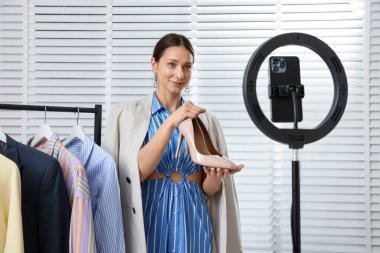 Profesyonel stilistin kapalı alanda akıllı telefon aracılığıyla müşteriyle çevrimiçi danışması