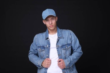 Siyah arka planda şık kot şapkalı genç adam.