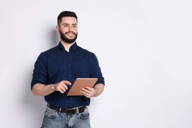 Beyaz arkaplanda tablet kullanan yakışıklı adam, metin için boşluk