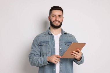 Yakışıklı adam beyaz zemin üzerine tablet kullanma