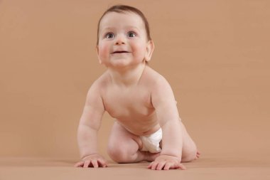 Bej arka planda emekleyen şirin bir bebek.