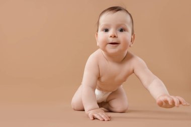 Bej arka planda emekleyen şirin bir bebek. Metin için boşluk