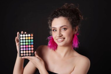 Siyah arka planda parlak göz falı olan gülümseyen kadın.