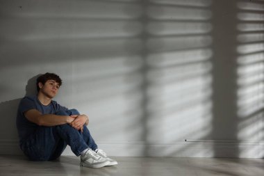 Gençlik sorunları. Açık duvarın yanındaki üzgün genç çocuk, mesaj için yer var.