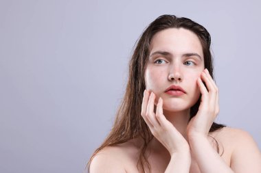 Gri arka planda doğal ten rengi olan güzel bir kadın. Yakın plan. Metin için boşluk