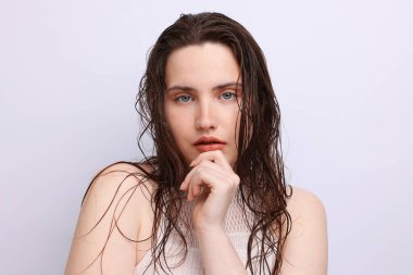 Açık gri arka planda doğal ten rengi olan güzel bir kadının portresi. Yakın plan.