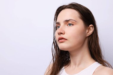 Açık gri arka planda doğal ten rengi olan güzel bir kadın. Yakın plan. Metin için boşluk